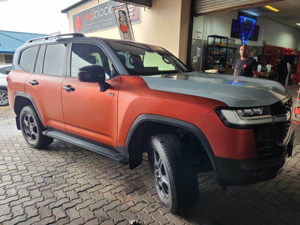Matte orange and Grey vinyl vehicle wrap installation on Land Cruiser
