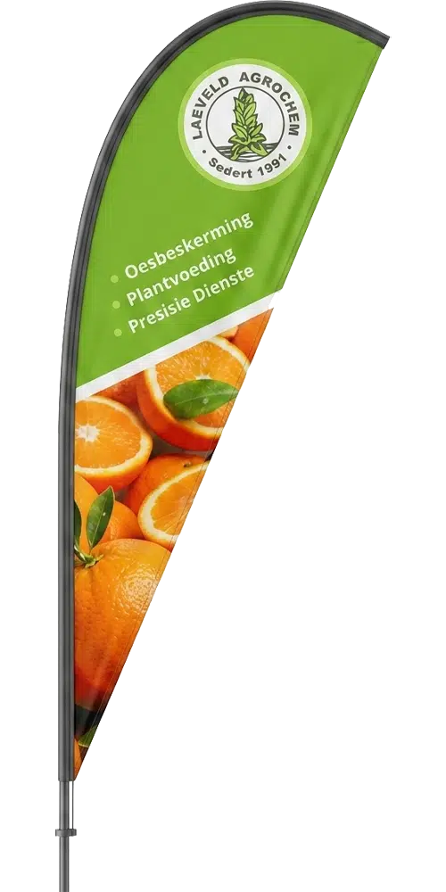An indoor mockup-style photo of a feather banner for Laeveld Agrochem on a clean white background. The banner is green on the top half with the Laeveld Agrochem logo and three bullet points of white text (in Afrikaans), and the bottom half is a detailed print of several whole and halved fresh oranges with a clear diagonal split.