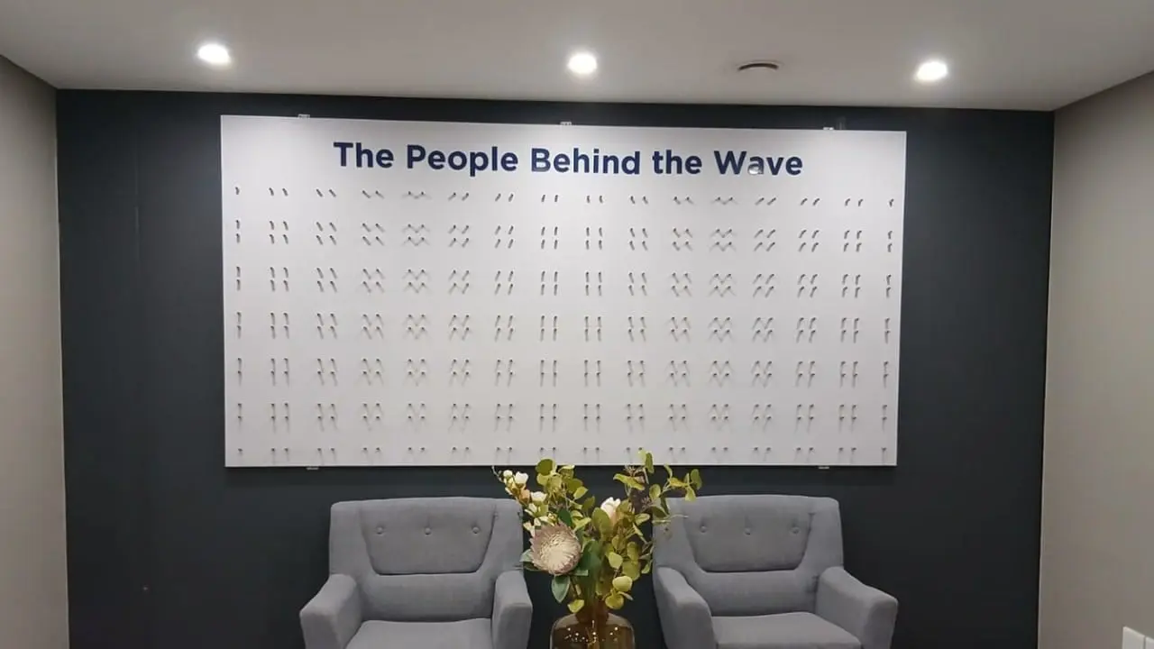 Custom ACM corporate display board with 360 standoffs installed on an office wall