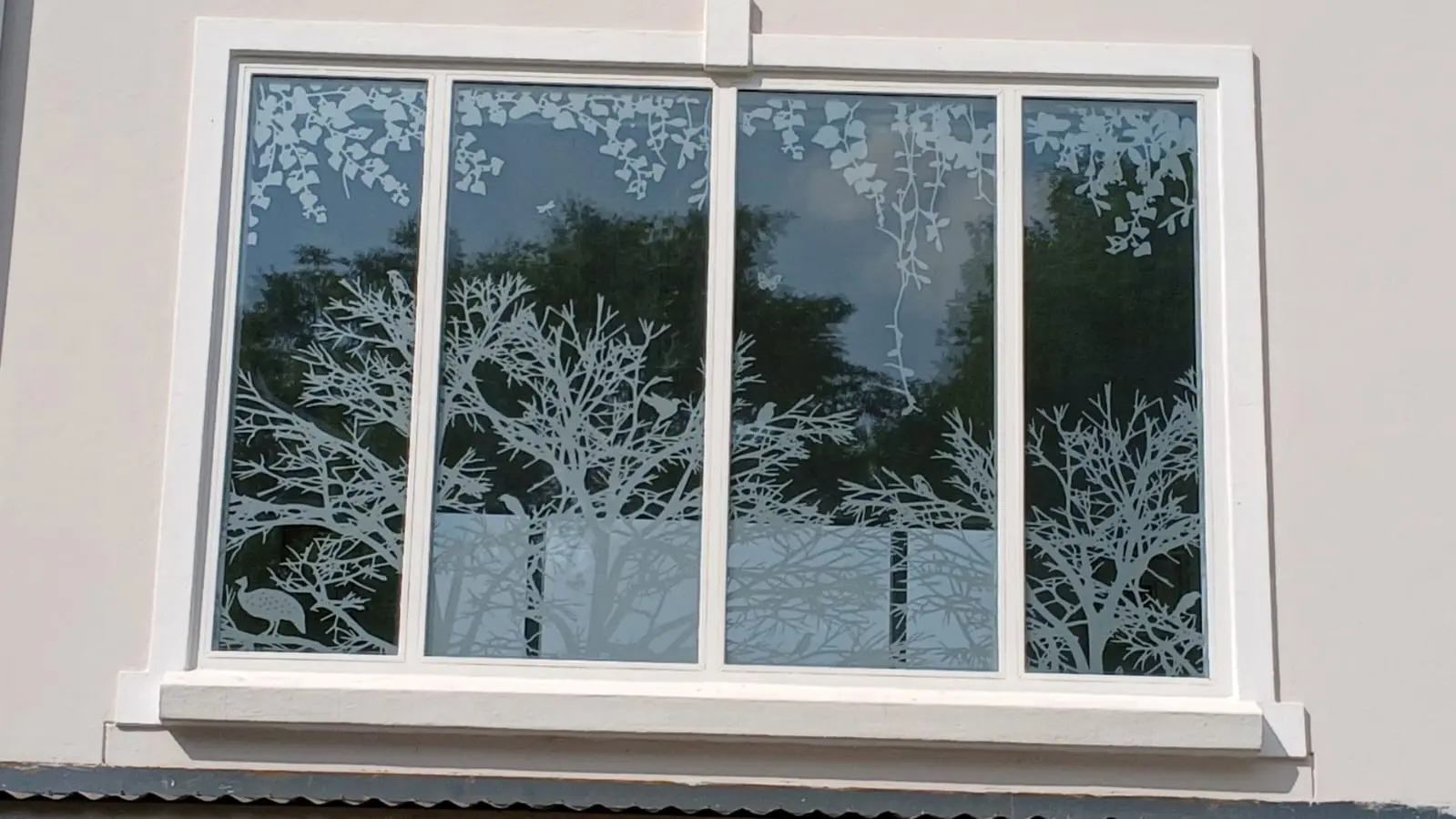 Nature-inspired frosted vinyl pattern applied across a four-panel exterior window