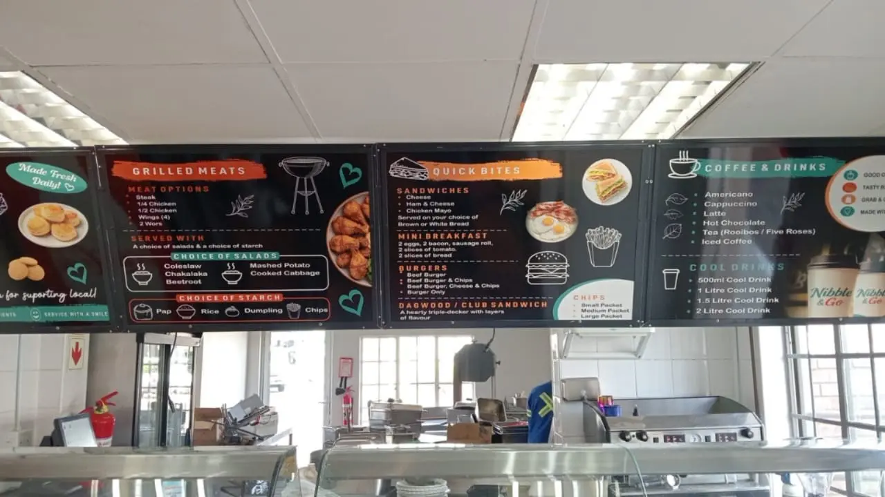 Internal Nibble and Go Cafe menu boards above the service counter at Tannery Industrial Park