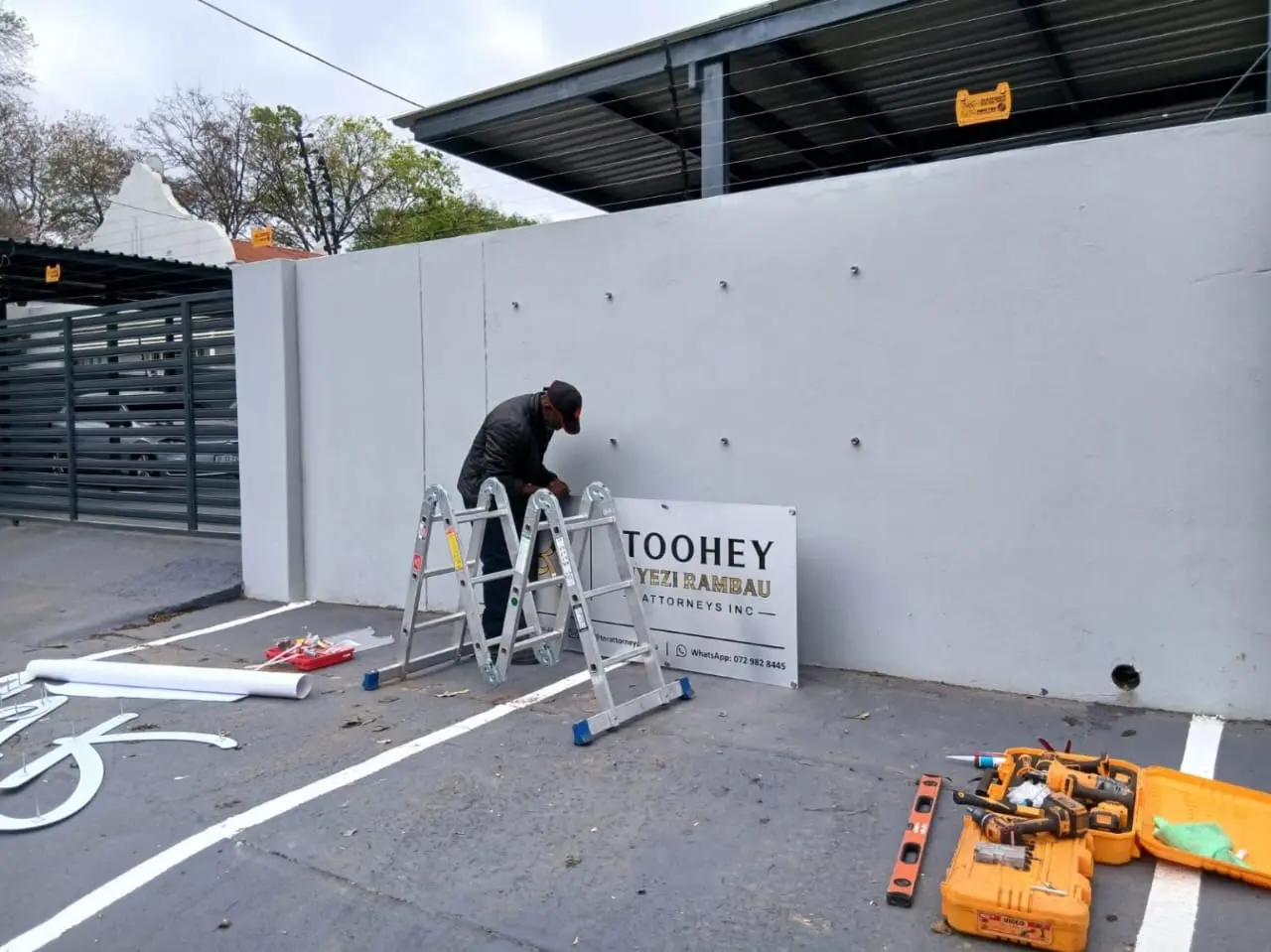 Installer fitting the exterior TNR Attorneys business sign in Pretoria