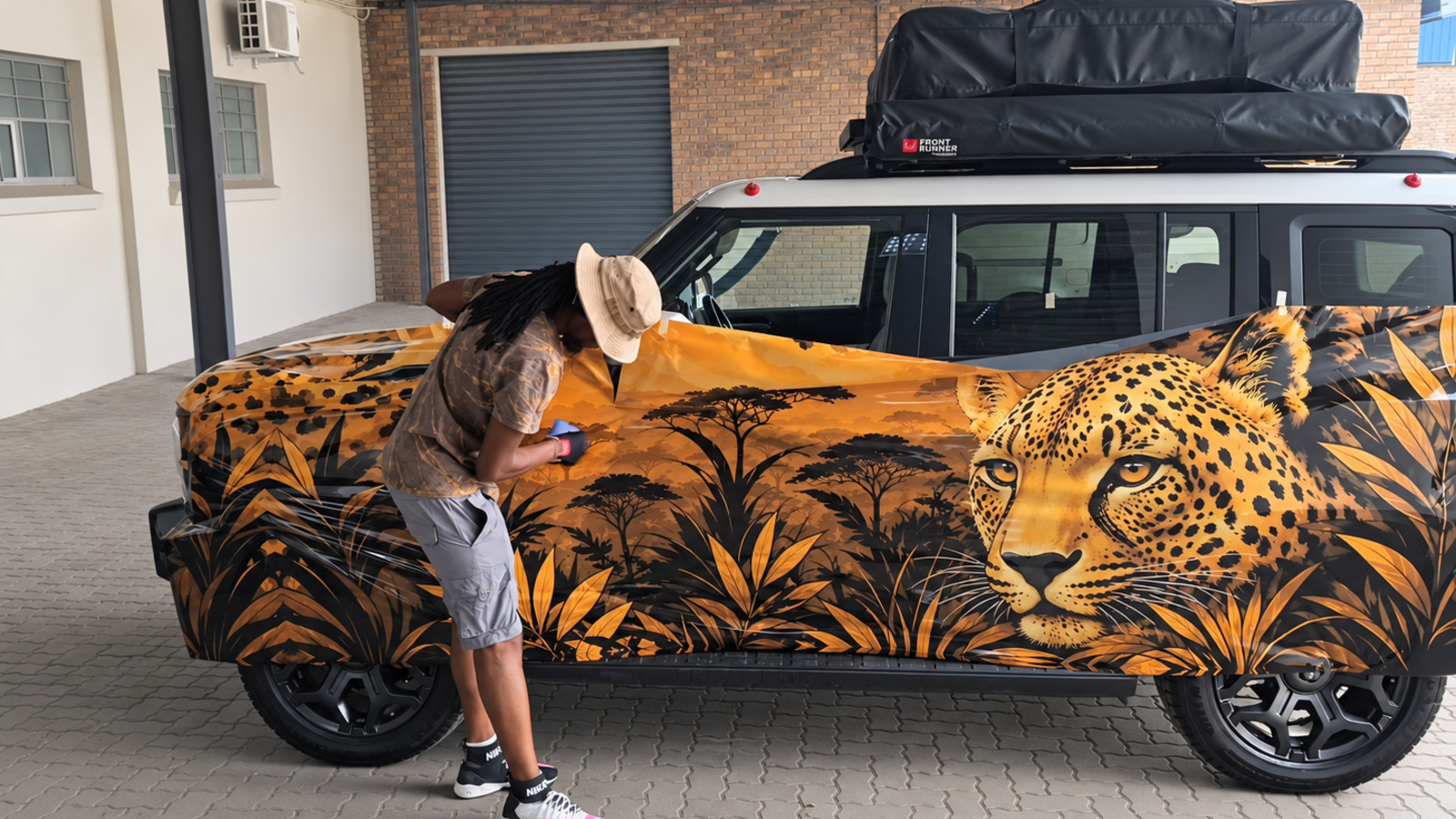 Technician applying the safari-inspired full vehicle wrap to a Jetour T2 in Pretoria